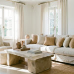 Déco maison forte chaleur : garder une maison élégante et fraîche Salon lumineux d’été aux tons clairs, avec fibres naturelles, fenêtres habillées de voilages et ambiance fraîche et élégante.